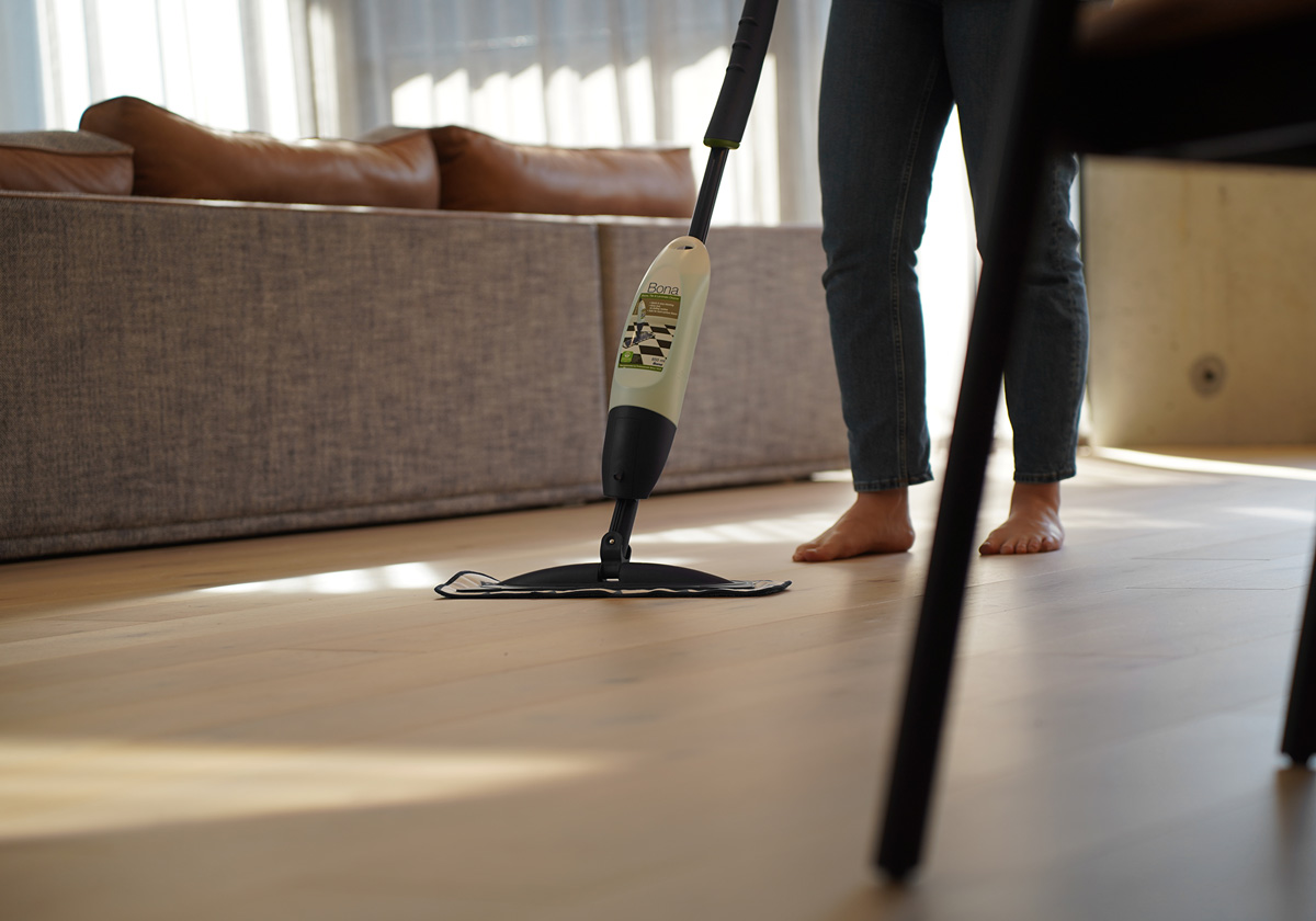 Woman cleaning timber floor with Bona cleaning kit